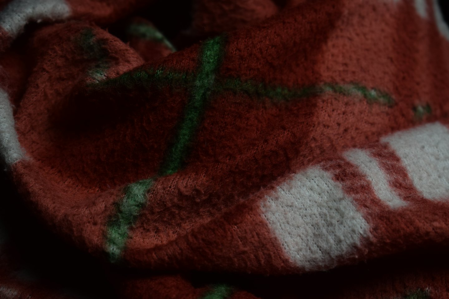 Soft fuzzy red green and white plaid blanket folded together.