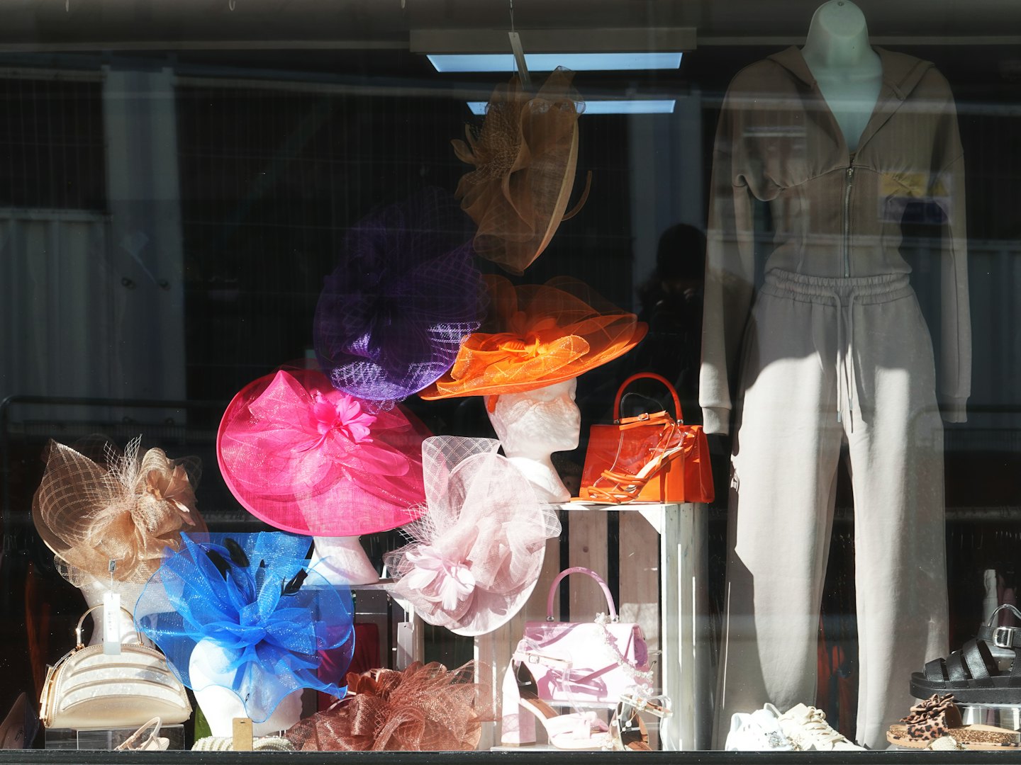 Colorful hats and clothing displayed in a shop window.